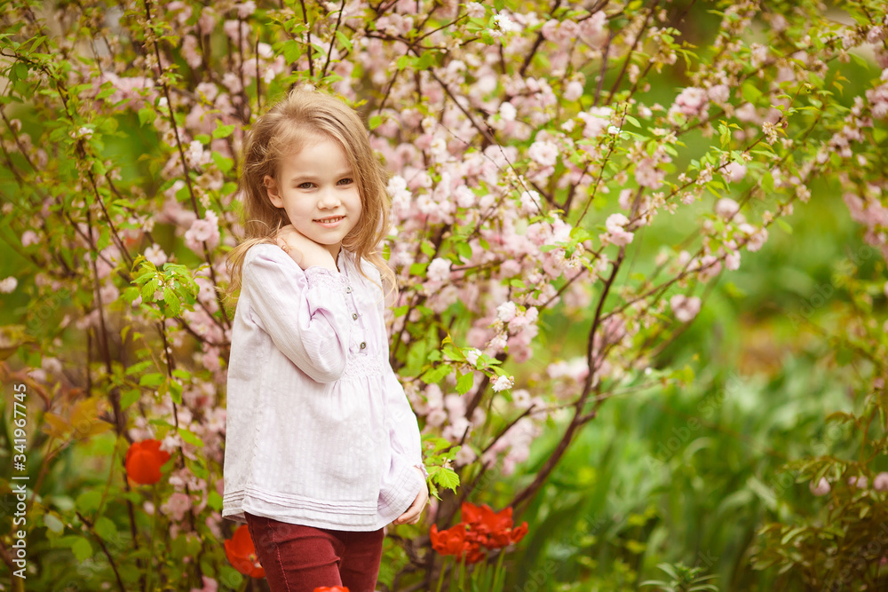 child girl in garden with almond bush and tulips child girl in garden with almond bush and tulips