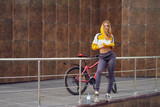 Young, athletic girl near a bicycle poses