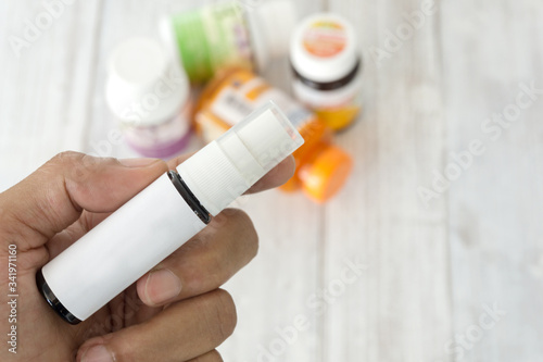The hand of a man holding a bottle of medicine with white lable for you text or product on background photo
