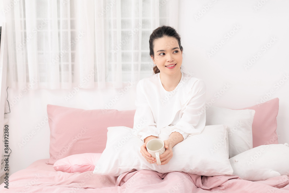 Beautiful happy young woman drinking cup of coffee or tea while lying in bed after waking up in morning. Beautiful happy young woman drinking cup of coffee or tea while lying in bed after waking up in morning.