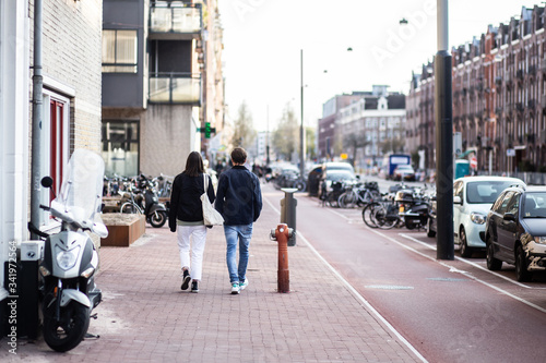 A couple (man and woman) man is walking in the street in Amsterdam