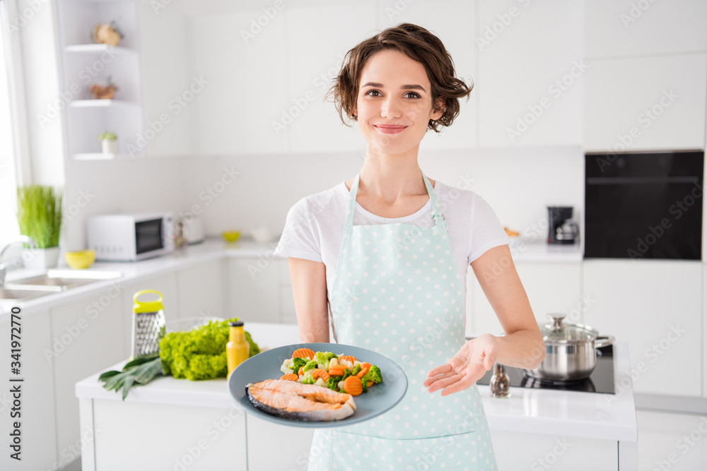 Have your gastronomy masterpiece, Photo of housewife lady chef showing grilled salmon trout fillet steak roasted garnish cook dinner one person portion wear apron modern kitchen indoors