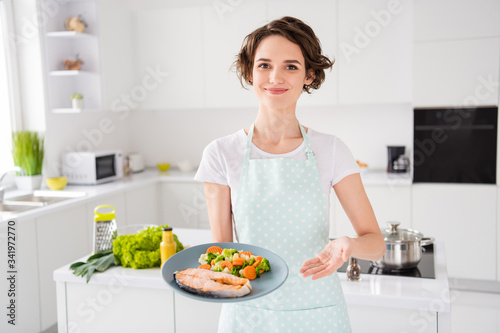 Have your gastronomy masterpiece  Photo of housewife lady chef showing grilled salmon trout fillet steak roasted garnish cook dinner one person portion wear apron modern kitchen indoors