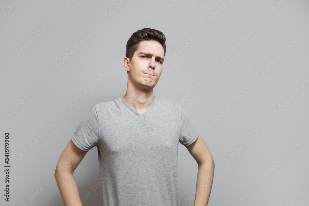 Obraz premium A guy in a gray T-shirt with emotions on his face.