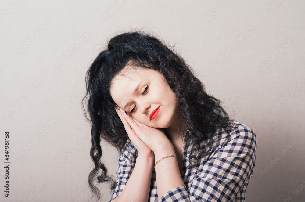 A woman wants to sleep. Gray background A woman wants to sleep. Gray background