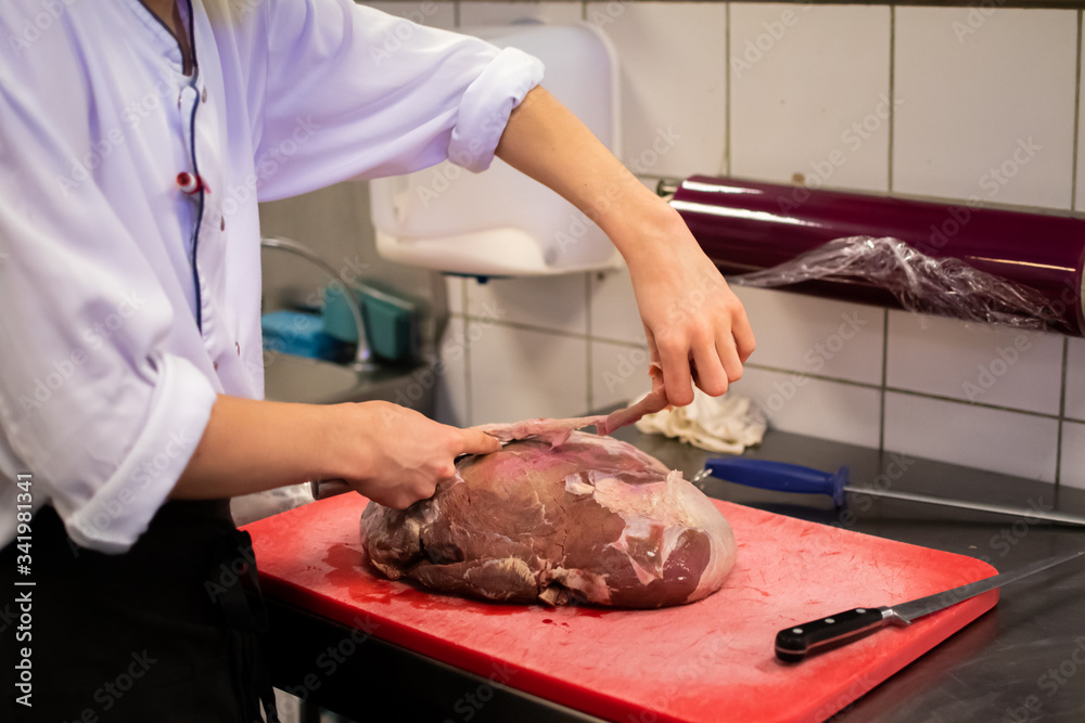 Chef cutting and preparing a large piece of meat