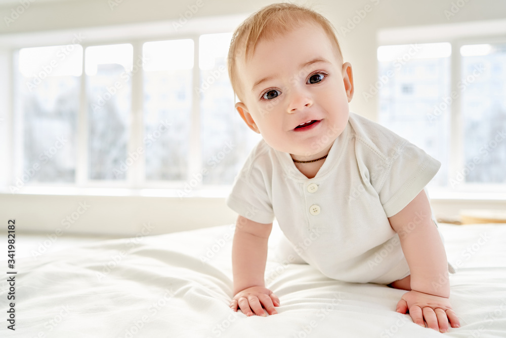 Close-up. A baby learns to crawl while standing on all fours on the bed. Close-up. A baby learns to crawl while standing on all fours on the bed.