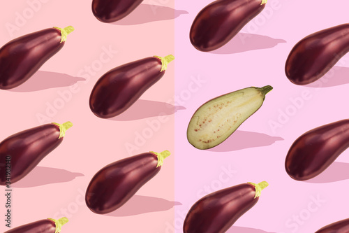 Flat lay colorful pattern with eggplant on pastel pink background. Trendy mockup or wallpaper. Minimal healhty lyfestyle concept with sharp shadows.