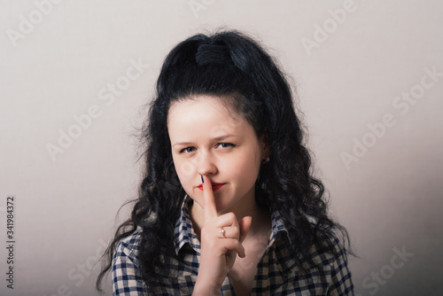 young woman making silence gesture, shhh!!