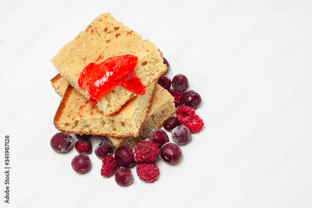 Semolina cake with raspberries cherries and strawberry jam isolated on white background Semolina cake with raspberries cherries and strawberry jam isolated on white background