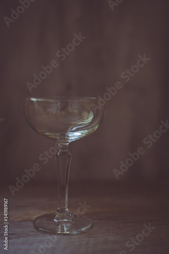 Empty coupe glass on vintage background