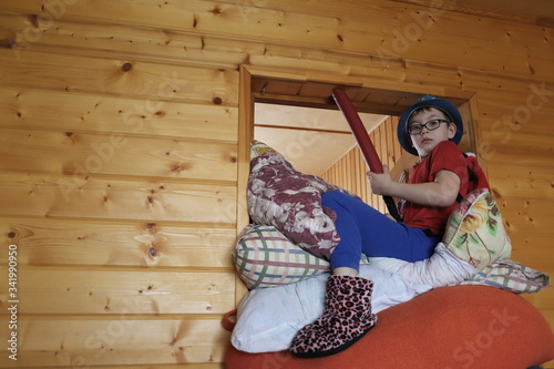 a boy plays on pillows like the king of the mountain, children's games in self-isolation mode