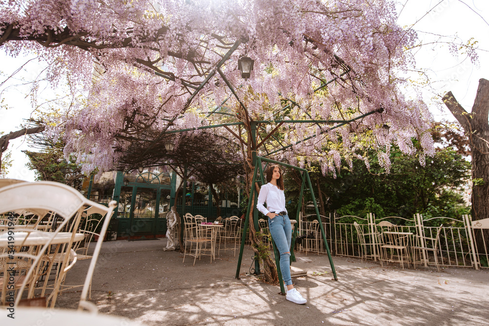 A beautiful young caucasian girl standing in the garden. Spring and flowers A beautiful young caucasian girl standing in the garden. Spring and flowers