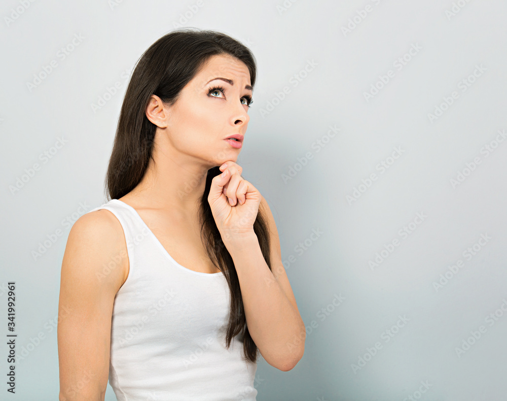 Concentrated young woman casual clothing with hand under the face find the solution on problem situation. Corona virus. Working at home. Studio portrait Concentrated young woman casual clothing with hand under the face find the solution on problem situation. Corona virus. Working at home. Studio portrait
