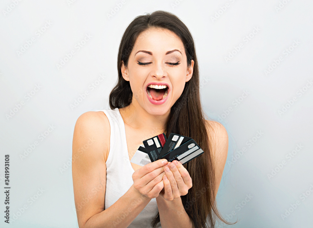 Happy excited woman holding in hands and showing many credit card with wide opened shouting mouth. Closeup portrait Happy excited woman holding in hands and showing many credit card with wide opened shouting mouth. Closeup portrait
