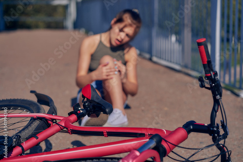 A girl fell in the city from a bicycle, examines a bruise.