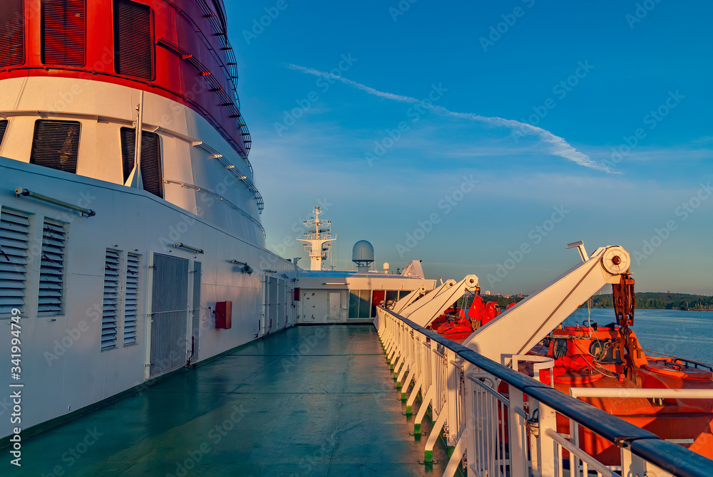Naklejka premium Clean empty ship deck on open sea with no one. Nice cruise ferry and life boat on side. Transportation industry on baltic. 
