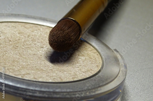 Highlighter makeup brush on gray background 