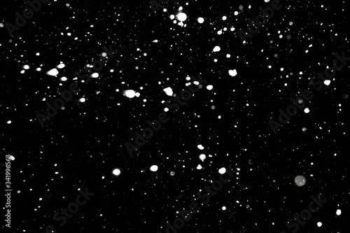 Snowfall in the night sky. Snowflakes on a black background.