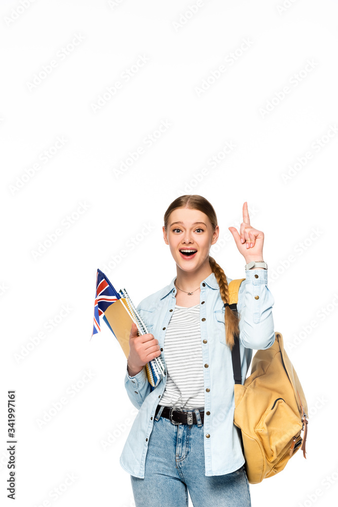 excited girl with backpack pointing up and holding copybooks and uk flag isolated on white excited girl with backpack pointing up and holding copybooks and uk flag isolated on white