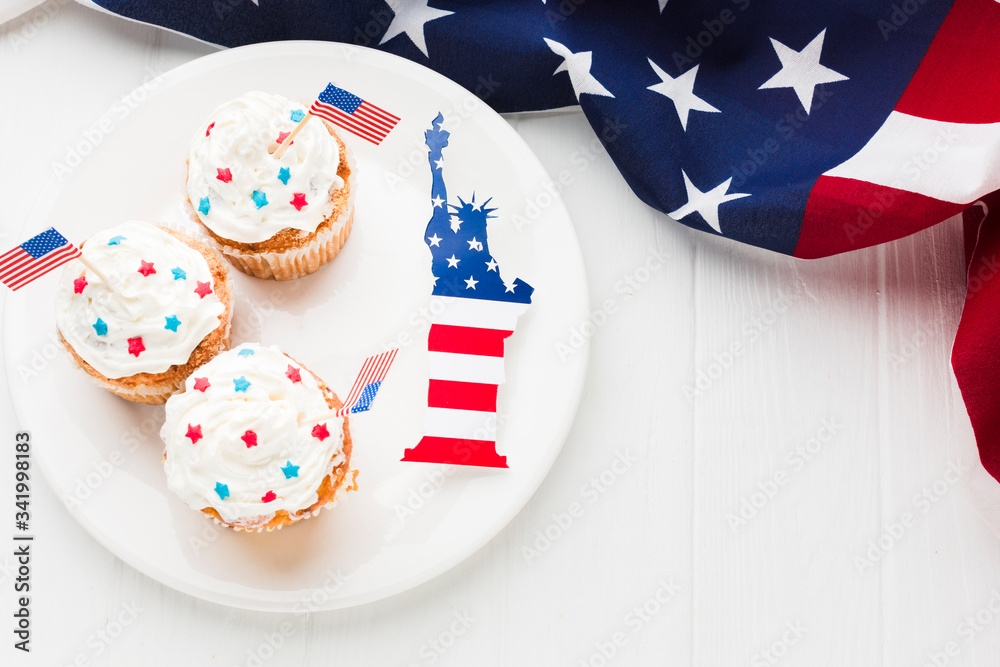 Obraz premium Top view of cupcakes on plate with statue of liberty and american flags