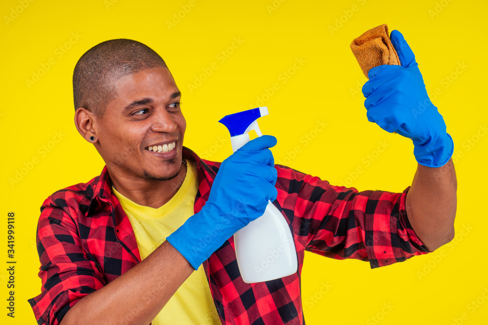 latin brazilian cleaning man wearing ribon gloves in studio yellow background latin brazilian cleaning man wearing ribon gloves in studio yellow background