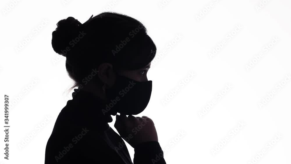 silhouette profile upset young woman in a protective mask bowed head down and praying for help on white isolated background, girl thinking about problem,