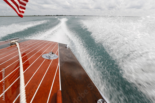 Εκτύπωση καμβά Back deck of a wooden boat speeding on a lake.