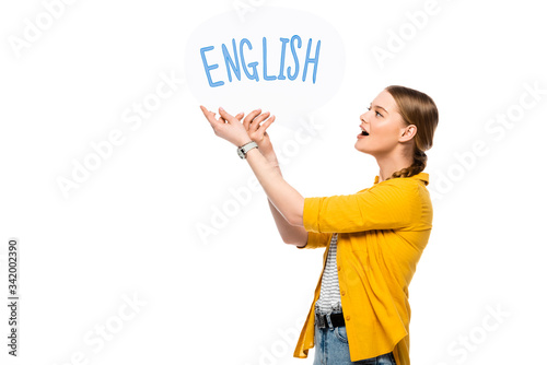side view of excited pretty girl with braid holding speech bubble with English lettering isolated on white