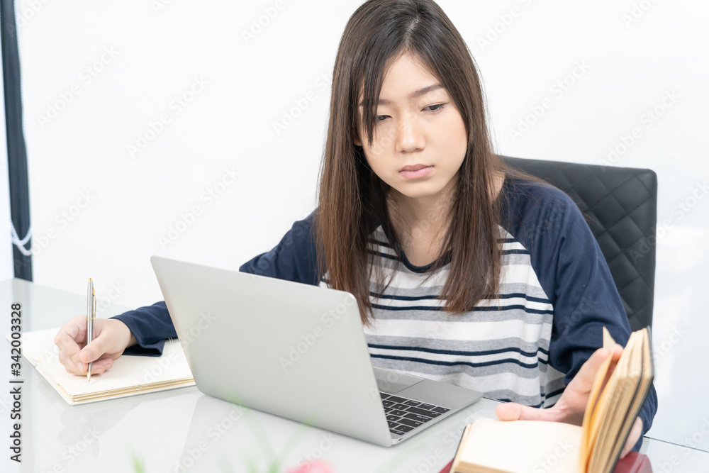 Young female student sitting in living room and learning online Young female student sitting in living room and learning online
