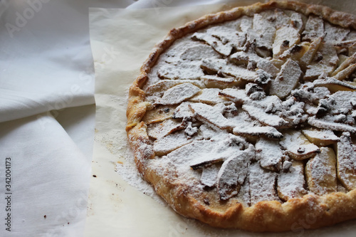 Apple pie sprinkled with powdered sugar. Homemade cake. Housework.