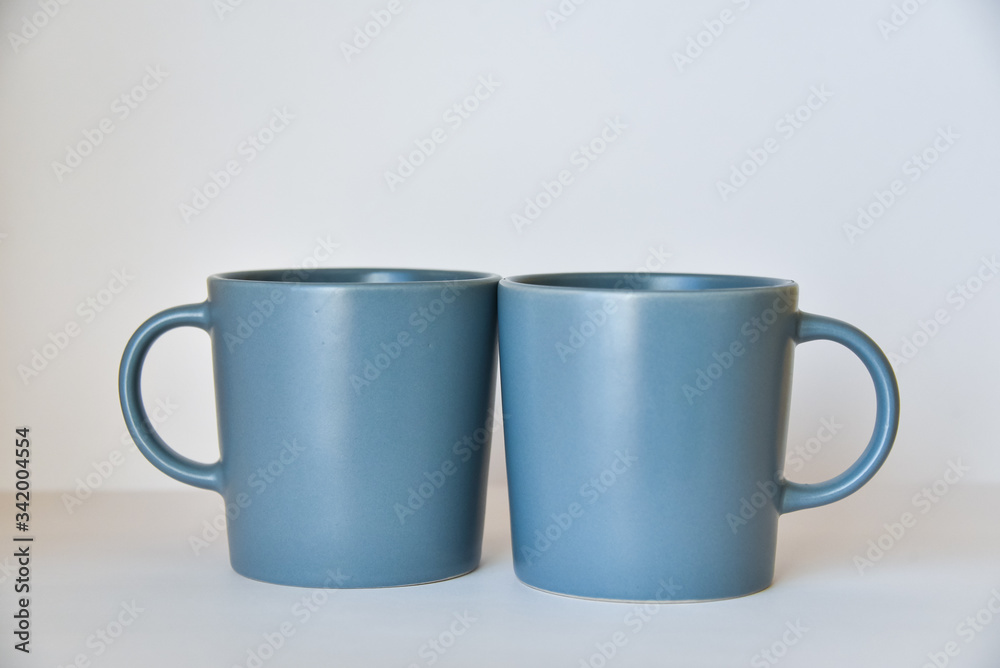 two coffee cups on a white table in a bright kitchen two coffee cups on a white table in a bright kitchen