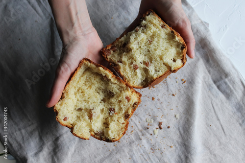 A broken cake with raisins in the hands of a girl. Homemade cake. Concept of homework during the quarantine period.