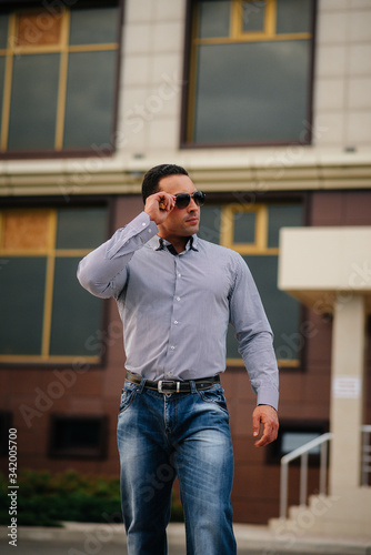 Young successful man near an office building. Business