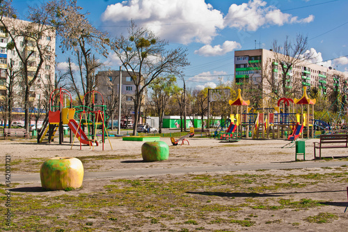 Public playground in the city without children. Colorful playground in the yard in the park surrounded by houses