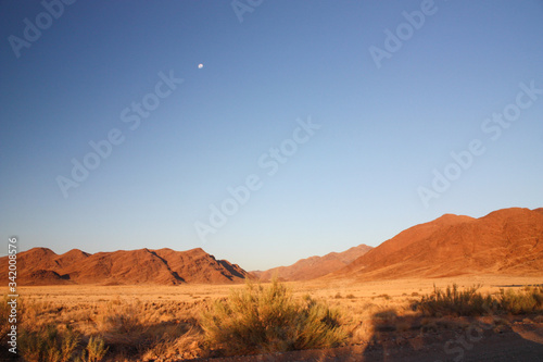 Desert mountains at sunset with rising moon