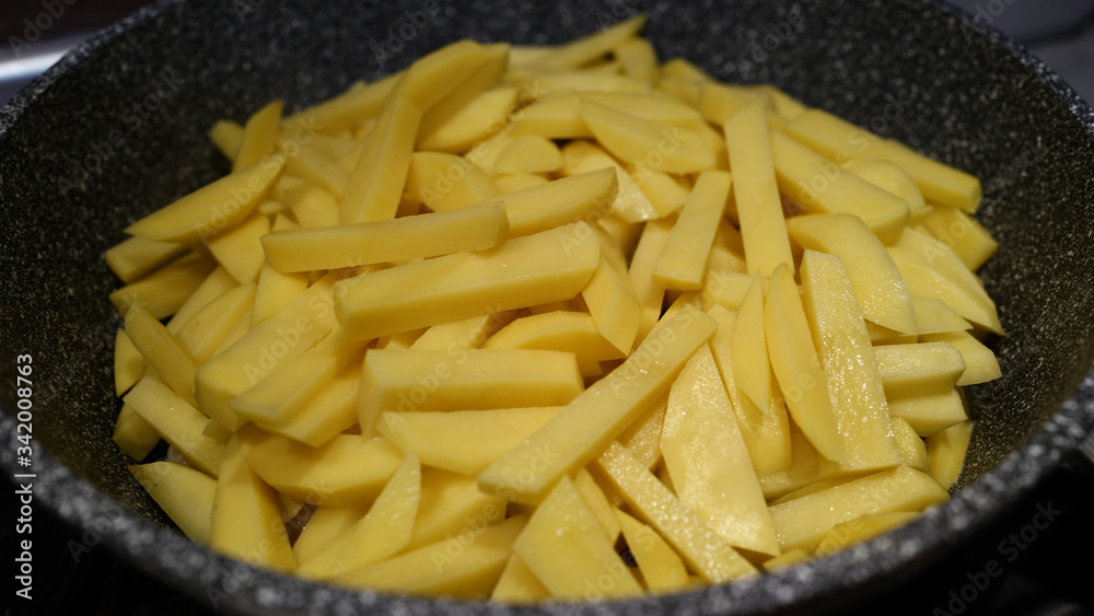 Raw chopped potatoes cooked for frying in a pan Raw chopped potatoes cooked for frying in a pan