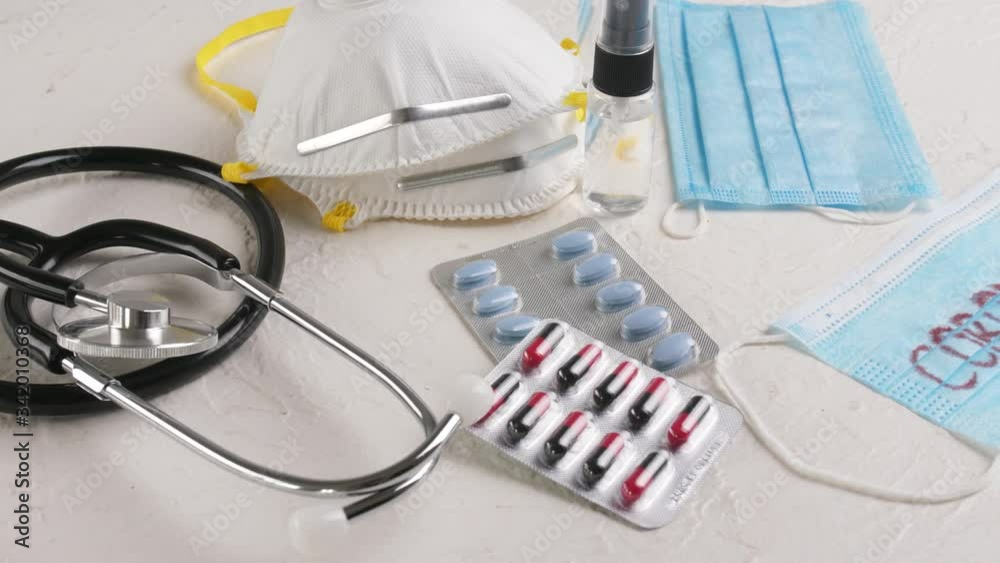 Stethoscope, protective medical masks, pills and disinfectant on white background. Concept of Coronavirus epidemic Stethoscope, protective medical masks, pills and disinfectant on white background. Concept of Coronavirus epidemic
