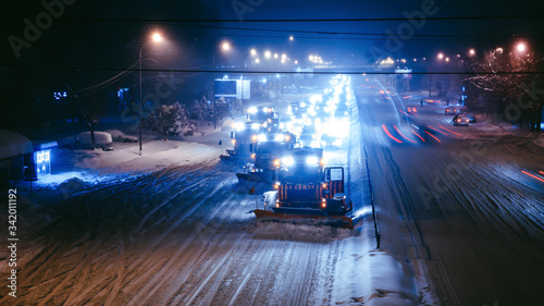 фотографія Working snow blowers shine on the road at night