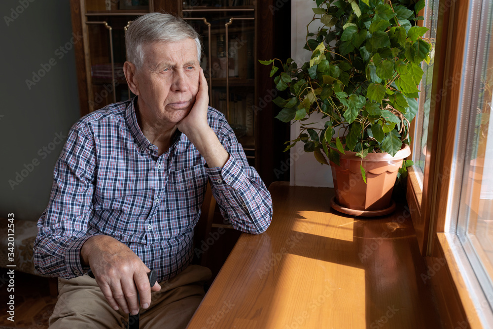 A handsome elderly man is at home, looking thoughtfully out the window. A handsome elderly man is at home, looking thoughtfully out the window.