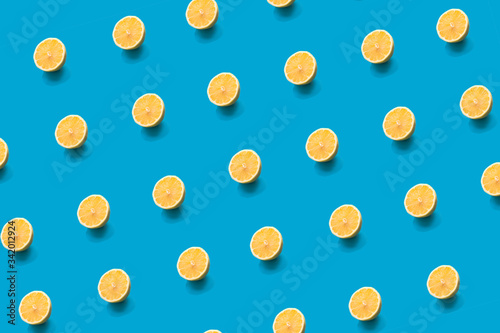 Pattern lemon fresh yellow half slice on bright blue background. Trendy summer minimal concept.