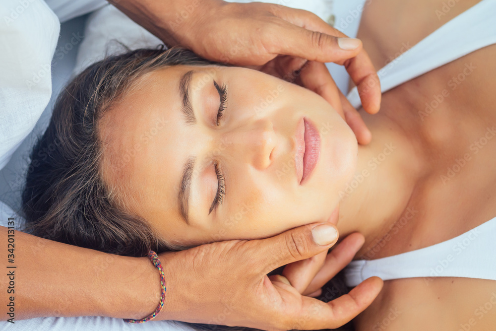 Close-up of young woman getting spa massage treatment by her husband