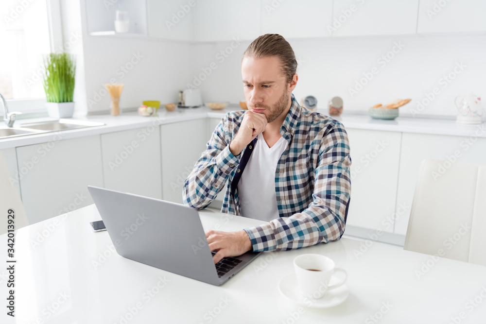 Portrait of focused minded guy sit kitchen table work distance use laptop read colleagues presentation analyze wear good look clothes in house light apartment Portrait of focused minded guy sit kitchen table work distance use laptop read colleagues presentation analyze wear good look clothes in house light apartment