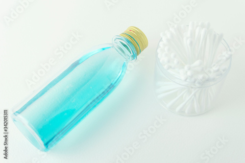 Alcohol bottle for disinfecting Placed on a white ground Next to a cotton ball to paint.jpg
