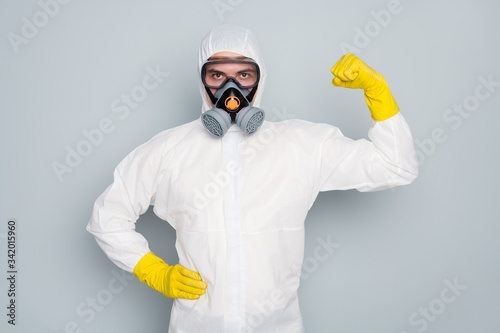 We save lives. Photo of disinfectant show strong biceps muscle pandemic highly recommend citizens stay home social isolation wear hazmat protective suit isolated grey color background