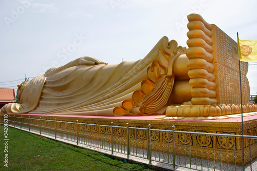 Big gloden sleeping or reclining buddha statue of Wat Lam Por Temple for thai people travelers visit respect praying at Koh Yo on August 16, 2019 in Songkhla, Thailand photo