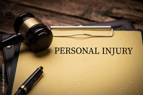 Personal Injury Law text on Document and gavel isolated on wooden office desk