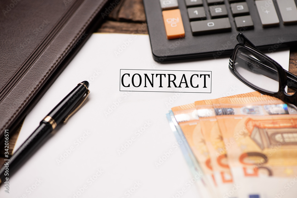 Contract text on Document and gavel isolated on wooden office desk Contract text on Document and gavel isolated on wooden office desk