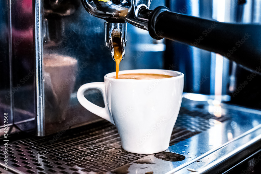 The coffee machine pours coffee into a white Cup The coffee machine pours coffee into a white Cup