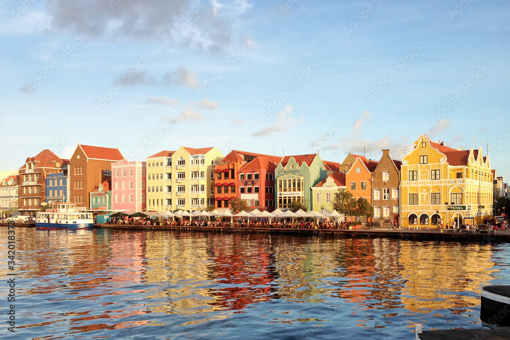 Willemstad/Curacao - Nov 15, 2016: The view of Willemstad harbour with colourful Dutch buildings in Curacao island. Bright reflection of beautiful houses in the water during sunny weather.